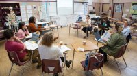 Group of teachers meet in a classroom