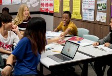 An image of a small group of middle school students collaborating on schoolwork